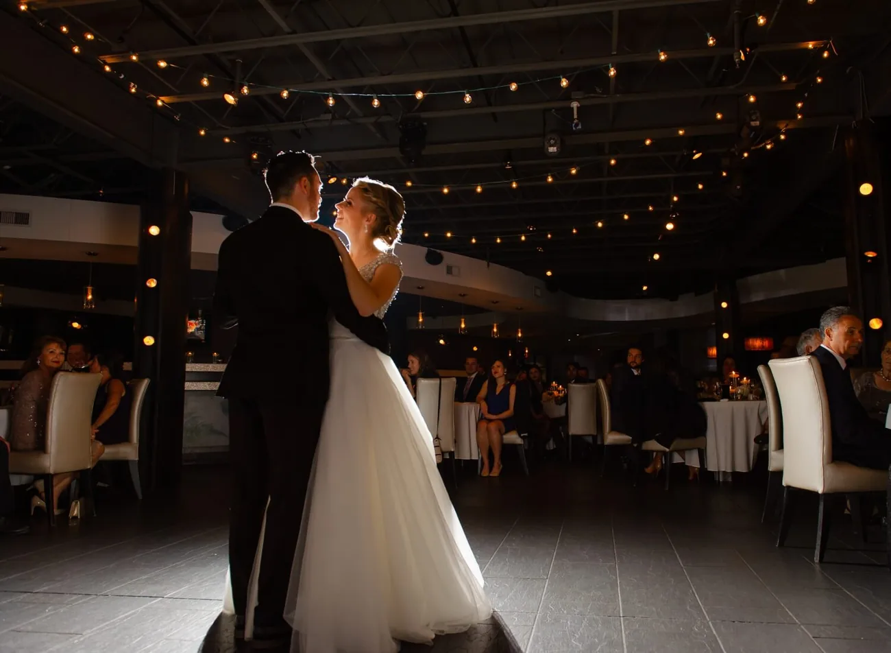 A couple's first dance, dramatically backlit