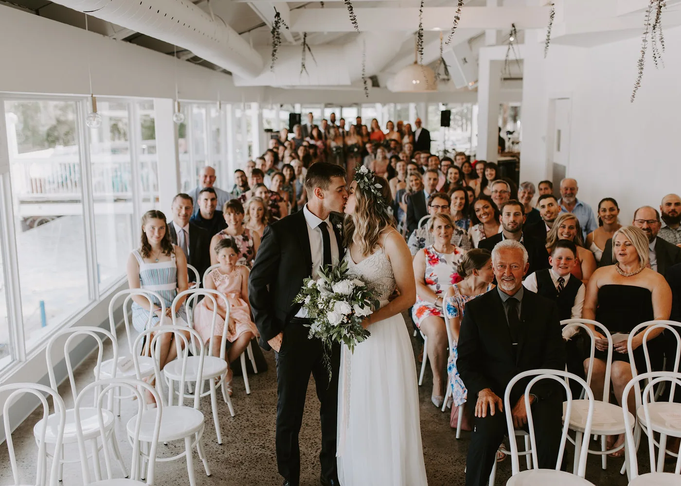 A wedding ceremony in the bright waterfront room at Umbrella Bar on Dow's Lake